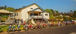 cream colored comunity hall with colorful motor bike s in front